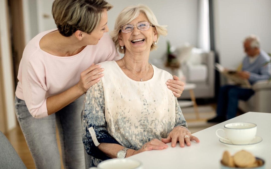 Szczęśliwa opiekunka ALHomecare rozmawiająca z seniorem przy herbacie – budowanie relacji w modelu live-in.